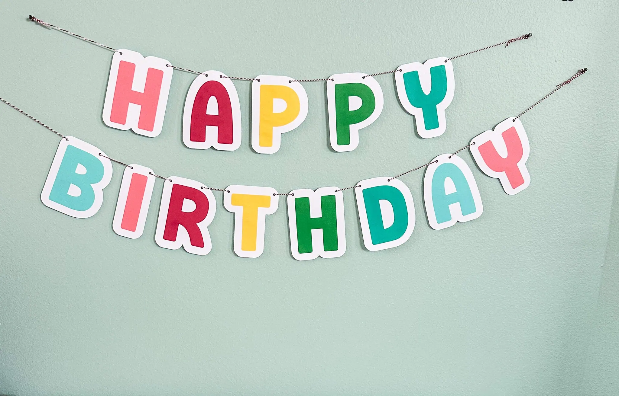 colorful happy birthday banner on aqua wall