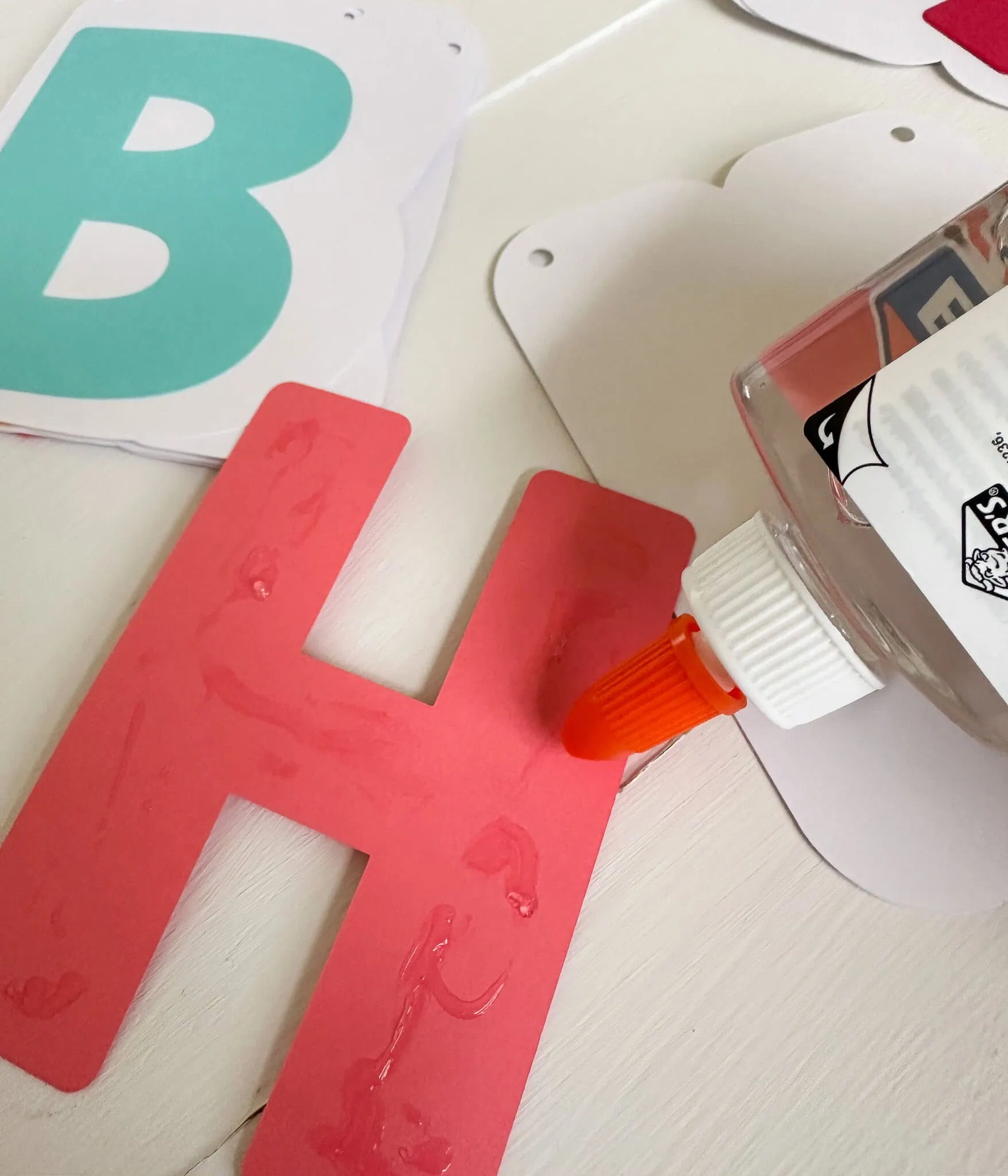 gluing letters to birthday banner background pieces