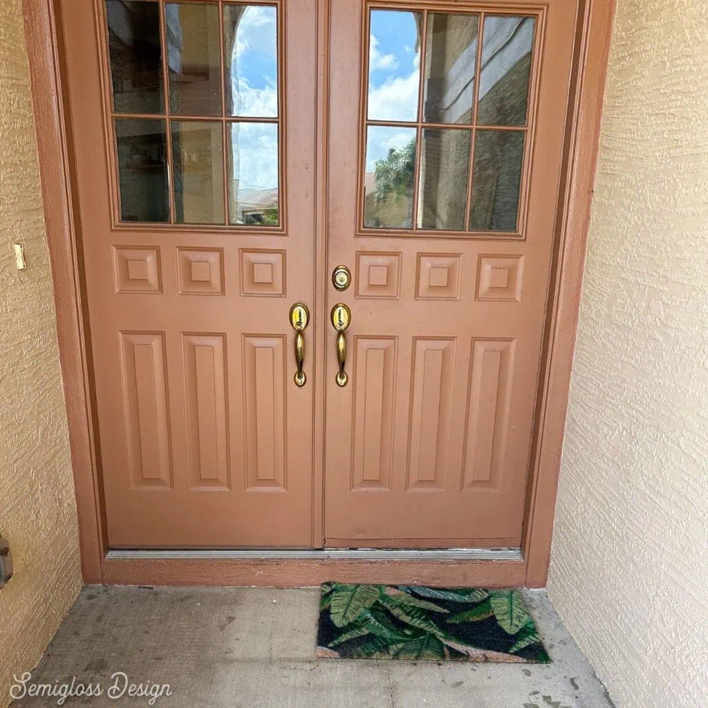 orange front door with small doormat