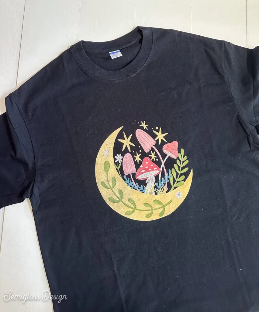 black shirt with printed moon and mushroom design